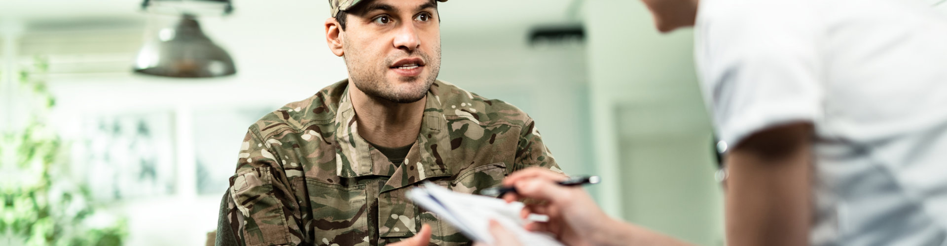 Young soldier communicating with female doctor at home.